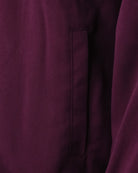 Close-up of purple track jacket side seam and stitched vertical pocket