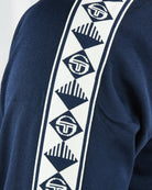 Navy track top: white geometric tape stripe with repeated logo patches