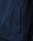 Navy track top close-up of front panel with vertical seam and tab