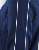 Navy track jacket shoulder and upper chest seam with vertical white stripe