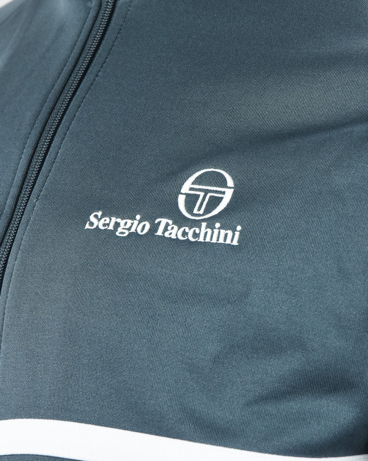 Sergio Tacchini logo and zipper edge on teal track jacket