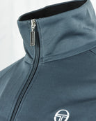 Teal track jacket with stand collar, silver zipper pull, and Sergio Tacchini logo