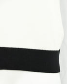 Cream knitted polo sleeve cuff and hem with black ribbed band.