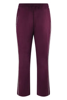 Burgundy track pants with white side stripes and tapered cropped legs