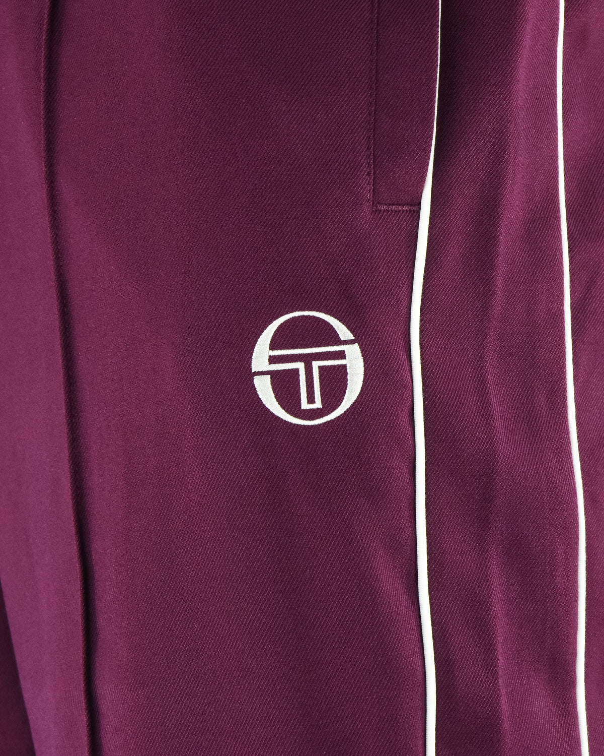 Burgundy track pants leg with white side stripe and Sergio Tacchini logo patch