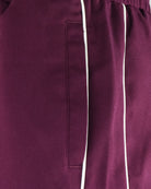 Burgundy track pants pocket with vertical white stripe detail