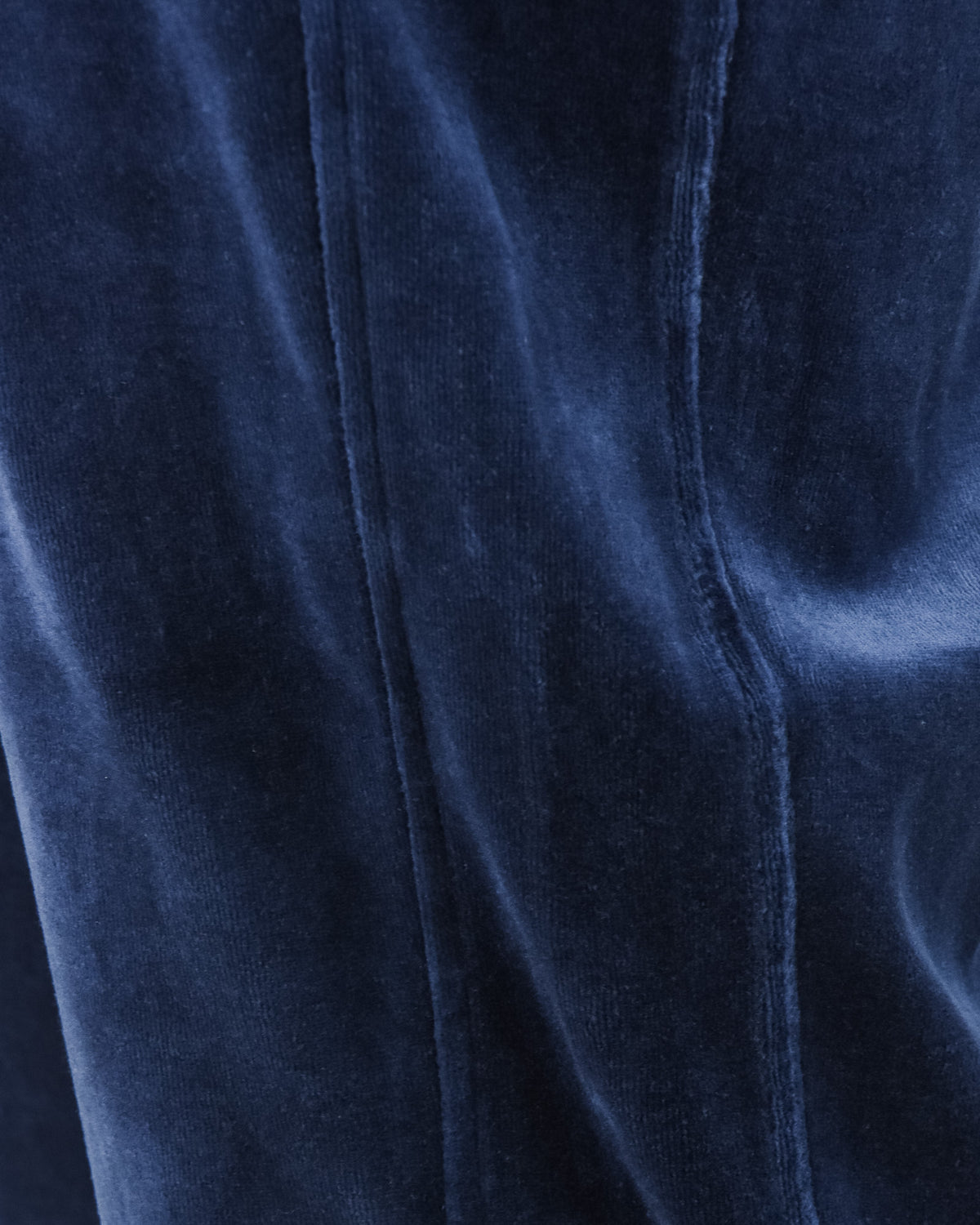 Velour track pants inner seam close-up on blue fabric