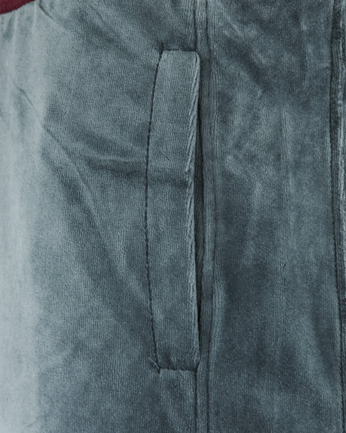 Velour track pants close-up: side seam and inner pocket detail