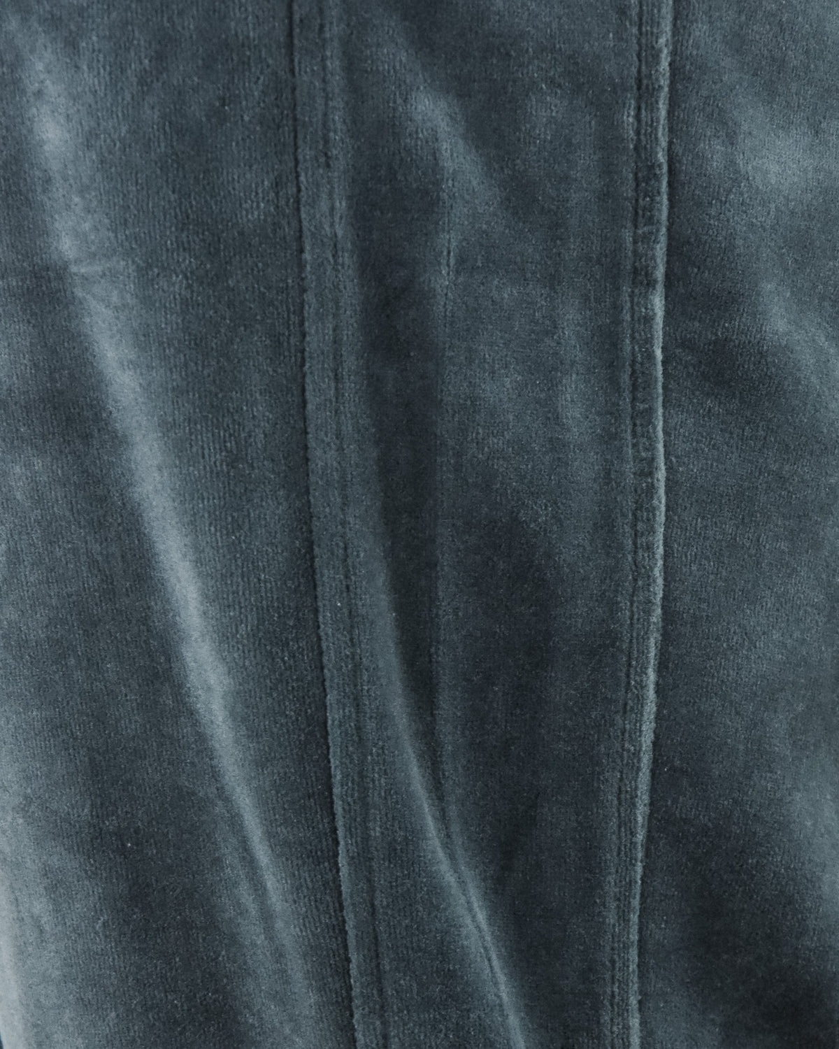 Velour track pants close-up: vertical front seam and fabric texture