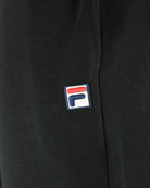 Black pants with embroidered Fila logo patch on the side seam