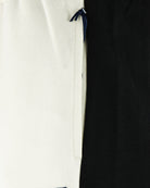 Cream track pants with black side panel and blue drawstring tie at waistband