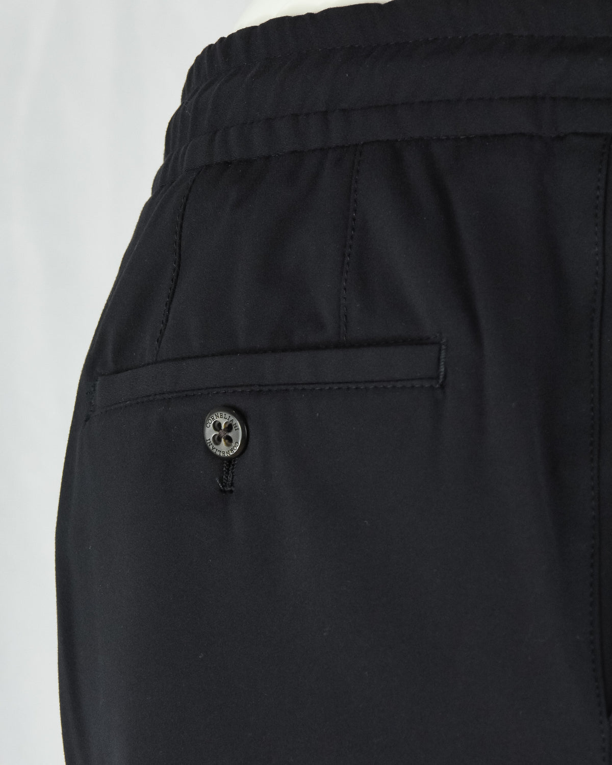 Black jersey stretch pant back yoke with button detail and stitched pocket