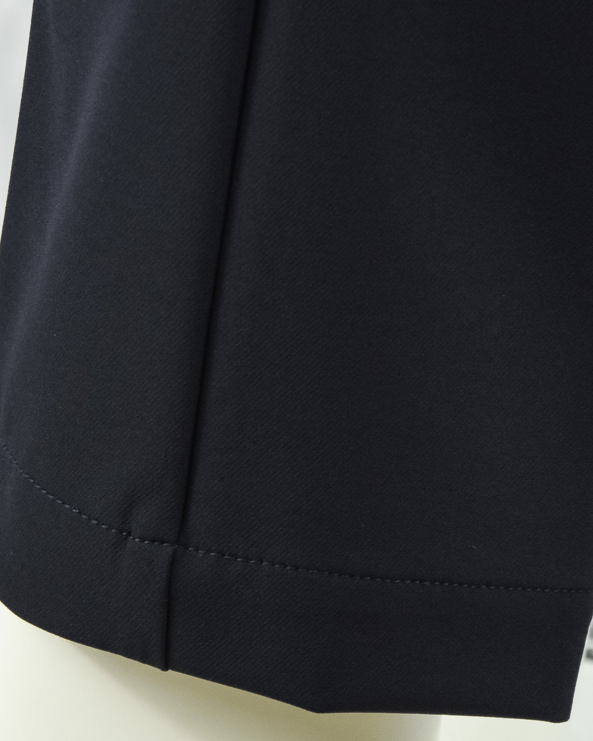 Navy tech pants hem with side seam and clean stitched finish