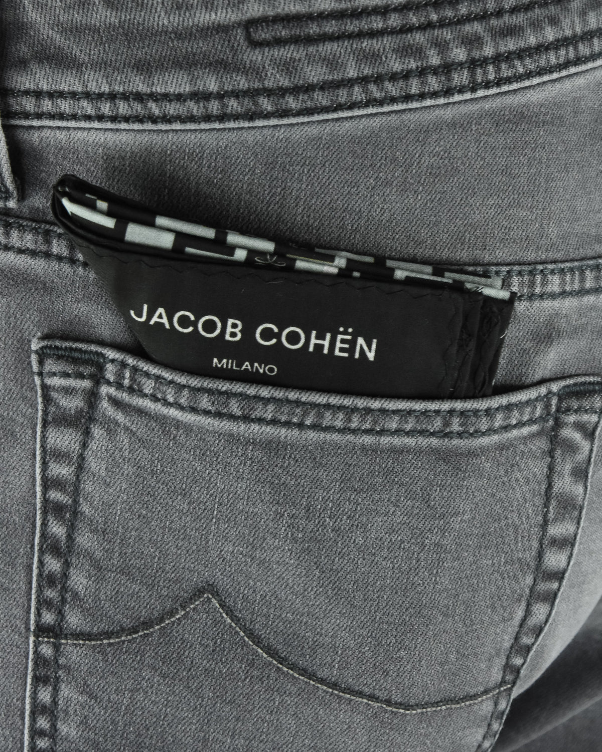 Denim jeans waistband close-up with Jacob Cohen logo patch and stitched inner trim