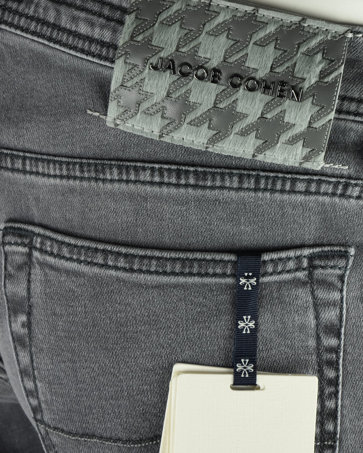 Denim jeans back yoke close-up with patterned Jacob Cohen patch and side label