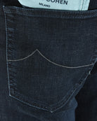 Curved back pocket with dark blue denim stitch lines and seam detail.