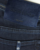 Waistband fabric patch with “Jacob Cohen” text and stitched edge on dark denim.