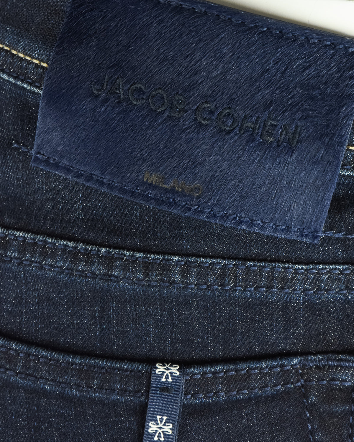 Waistband fabric patch with “Jacob Cohen” text and stitched edge on dark denim.
