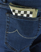 Dark blue denim jeans close-up of coin pocket and brand patch