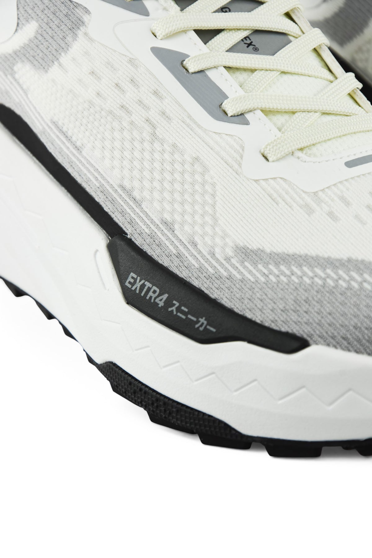 Side view detail of white and gray waterproof running shoe with black trim