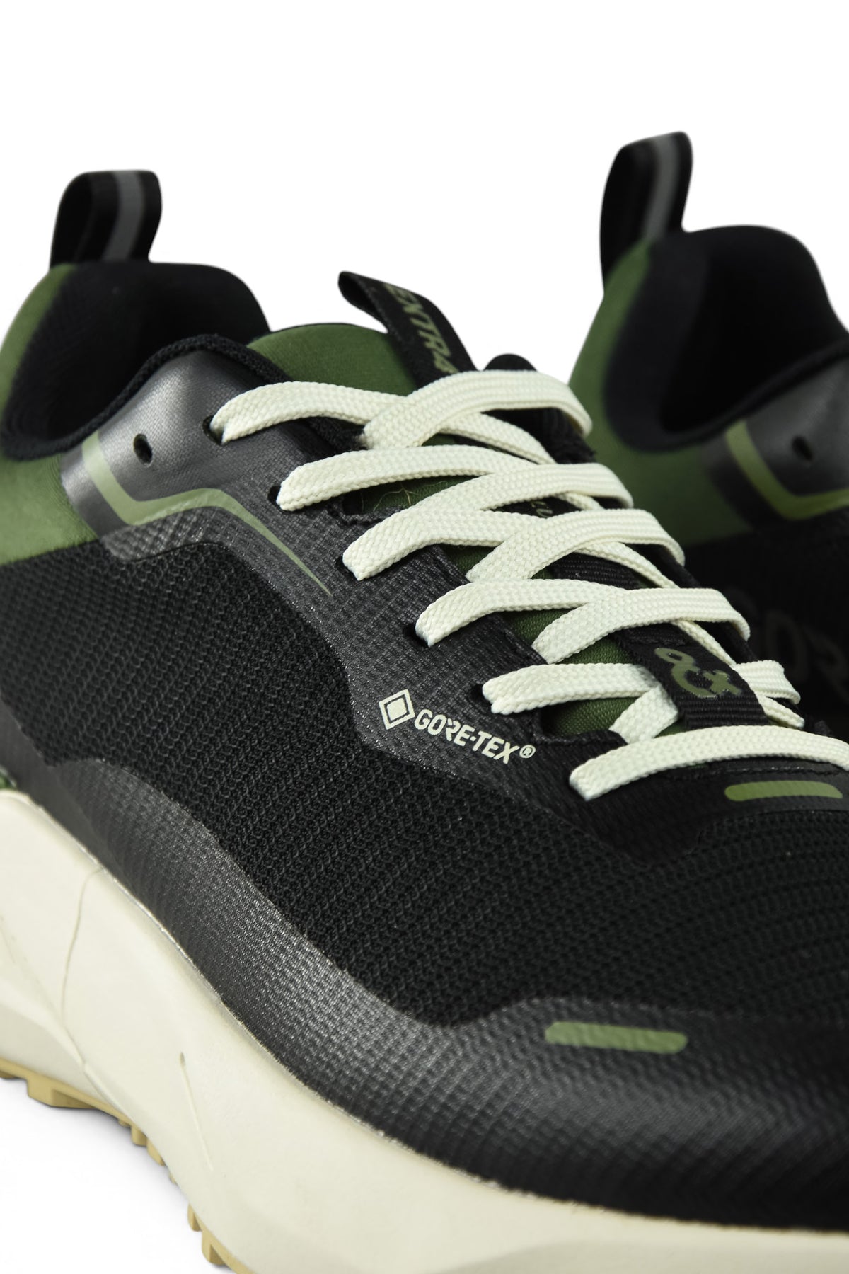 Waterproof GTX running shoe close-up of toe and laces, black upper with green details