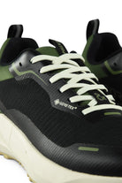Waterproof GTX running shoe close-up of toe and laces, black upper with green details