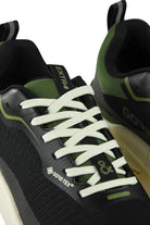 Waterproof GTX running shoe lace and side logo close-up in black with green trim