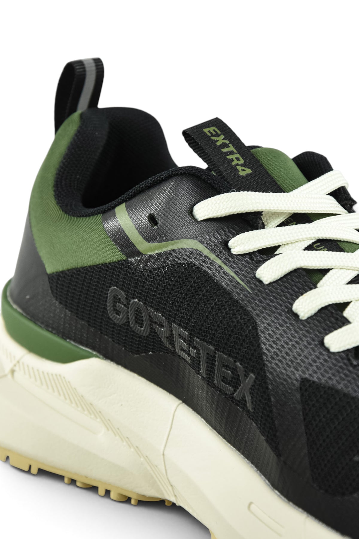 Waterproof GTX running shoe tongue and lace area close-up in black with green stripe