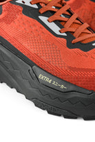 Rust orange upper and black midsole with EXTRA branding on textured outsole