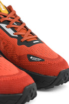 Rust orange waterproof running shoe with black trim and Gore-Tex Waterproof logo badge