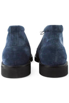 Navy suede chukka boots, heel view with lace-up tabs and dark rubber soles