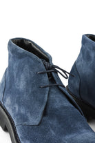 Navy suede chukka boot close-up showing lace-up and padded collar