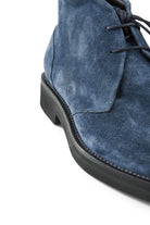 Navy suede chukka boot close-up of laces, vamp seam, and side panel