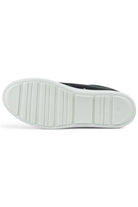 White rubber outsole with textured tread for a navy low-top leather sneaker.