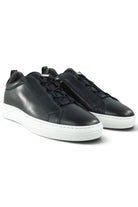 Pair of navy leather low-top sneakers with lace-up front and white rubber sole.