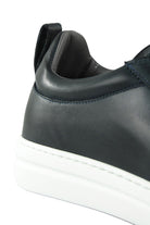 Navy leather low-top sneaker heel with padded collar and white rubber midsole.