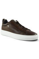 Brown leather low-top trainer with lace-up and white sole, side profile view