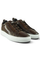 Pair of brown leather low-top trainers with lace-up and white rubber soles