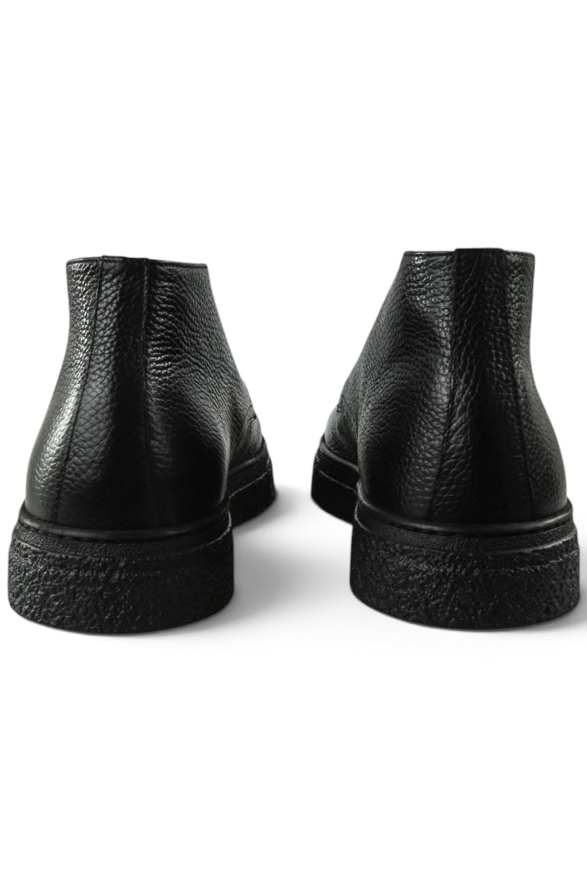 Back view of black leather ankle boots showing stacked heel and tread sole.
