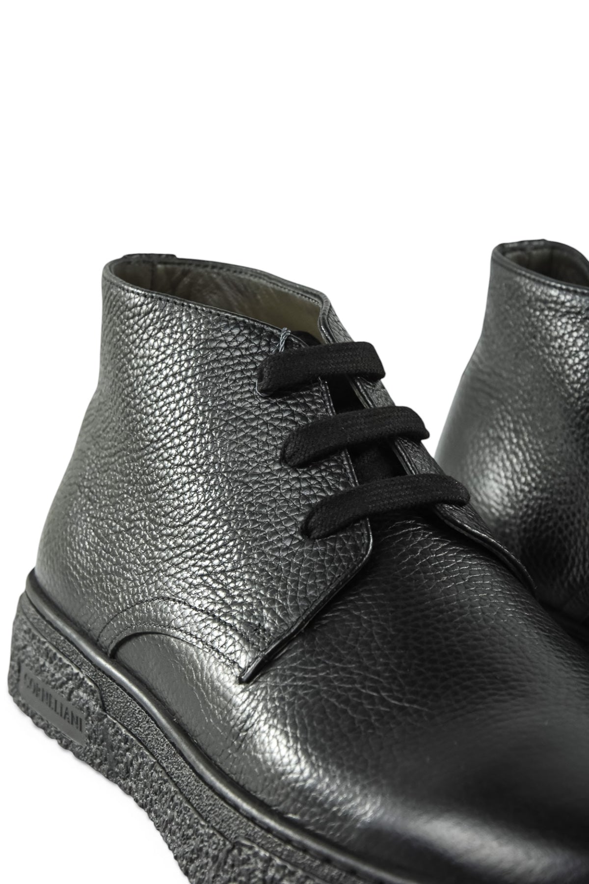 Side view of black leather lace-up ankle boot with textured sole edge.