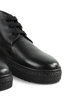 Close-up side view of black leather lace-up ankle boot with tread sole.