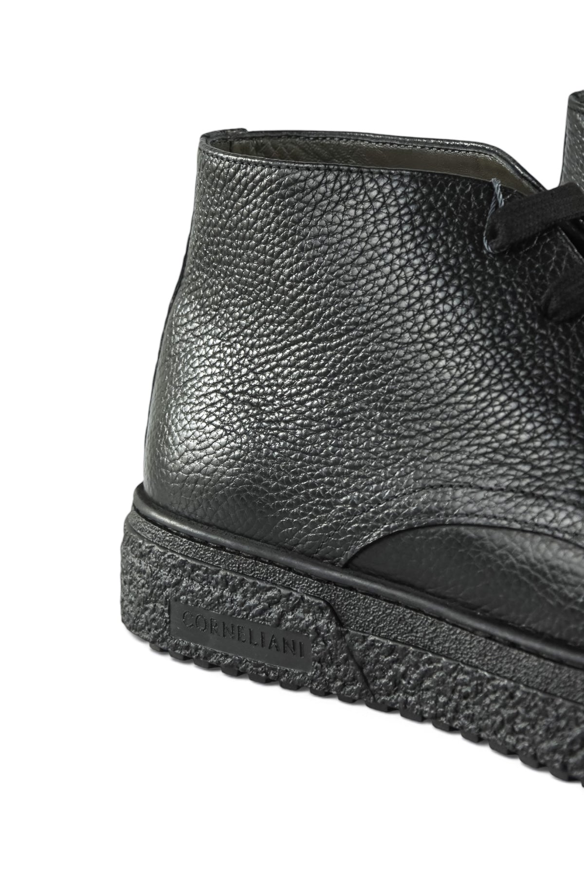 Close-up of black leather ankle boot with lace, stitching, and thick sole.