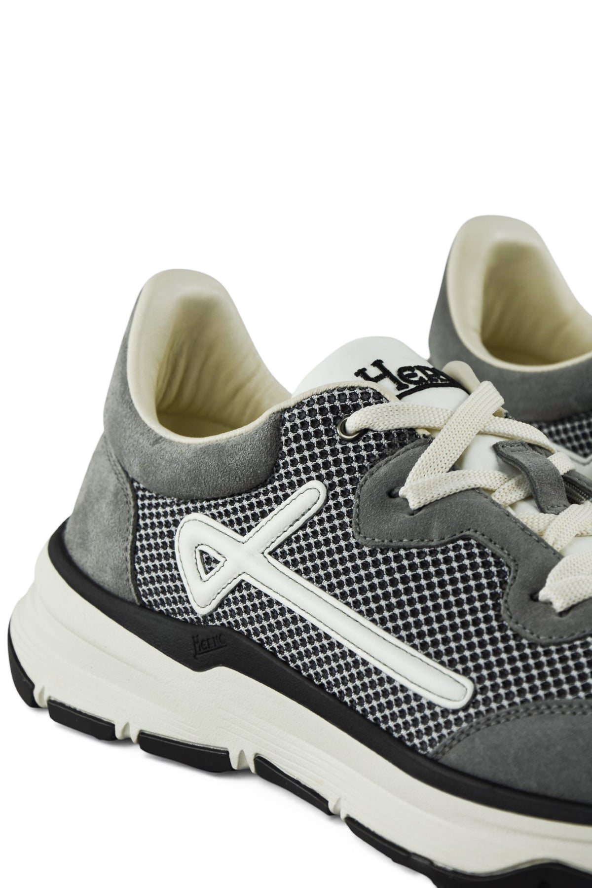 Grey trainers close-up of side panel, textured knit, and white lace-up detail