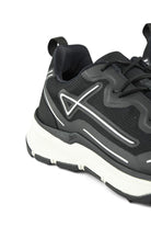 Close-up of black mesh trainer upper with lace eyelets and reflective side stripe
