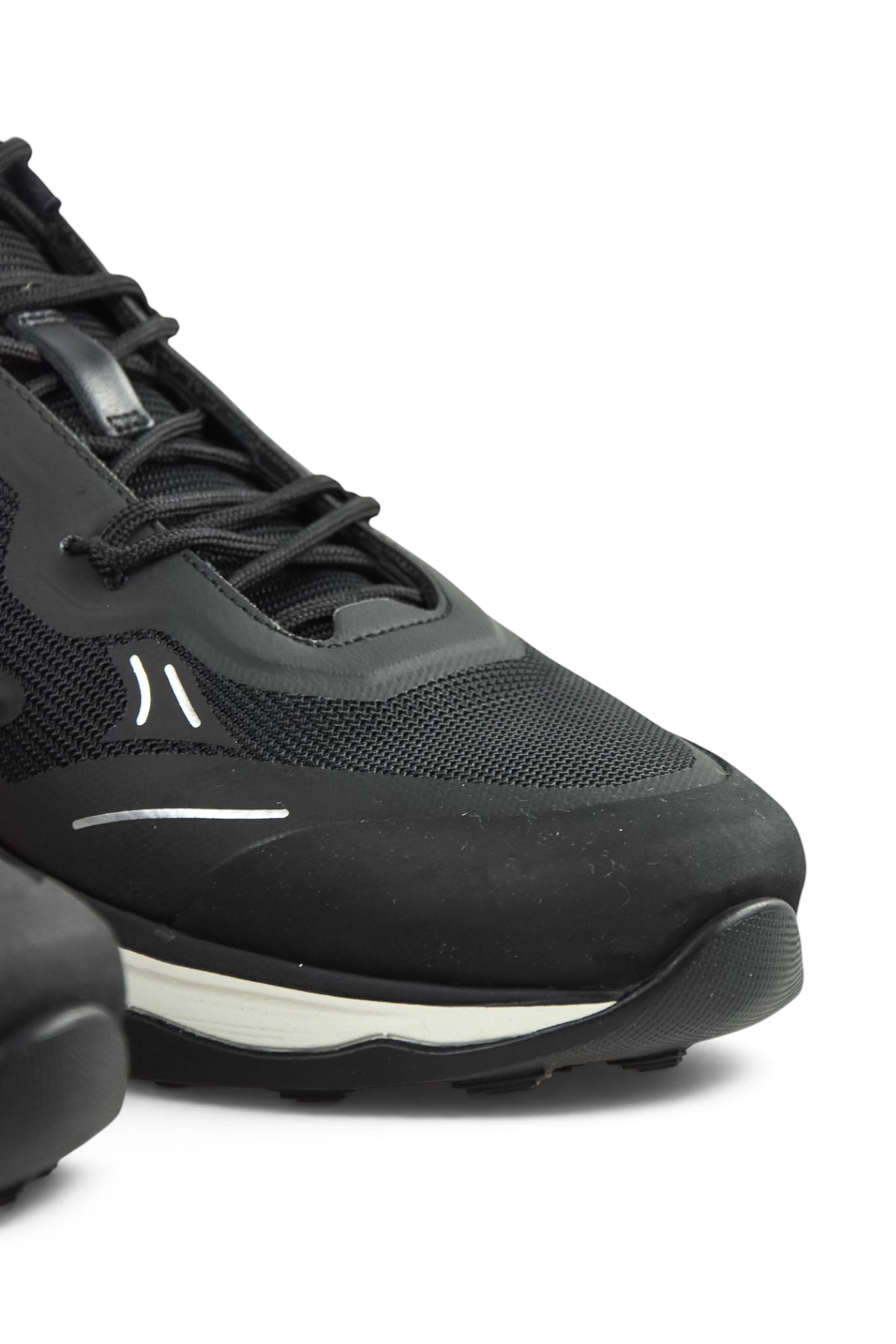 Front-side close-up of black mesh trainer with lace-up closure and sculpted sole