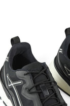 Close-up of black trainer heel and tongue with lace-up top and side logo