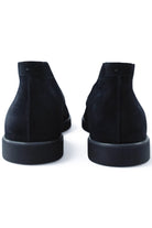Back view of blue suede chukka desert boots with low-profile rubber sole.
