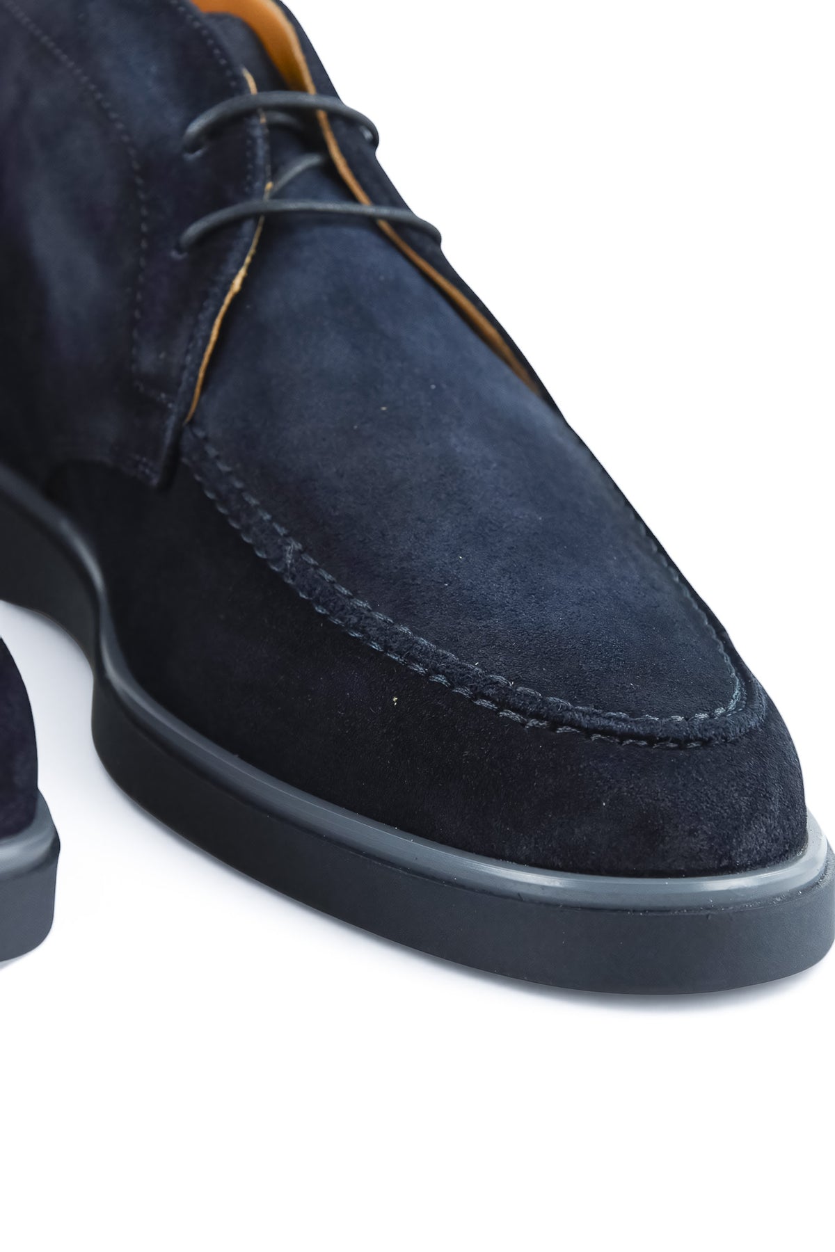 Close-up of blue suede chukka desert boot with contrast stitching and laces.