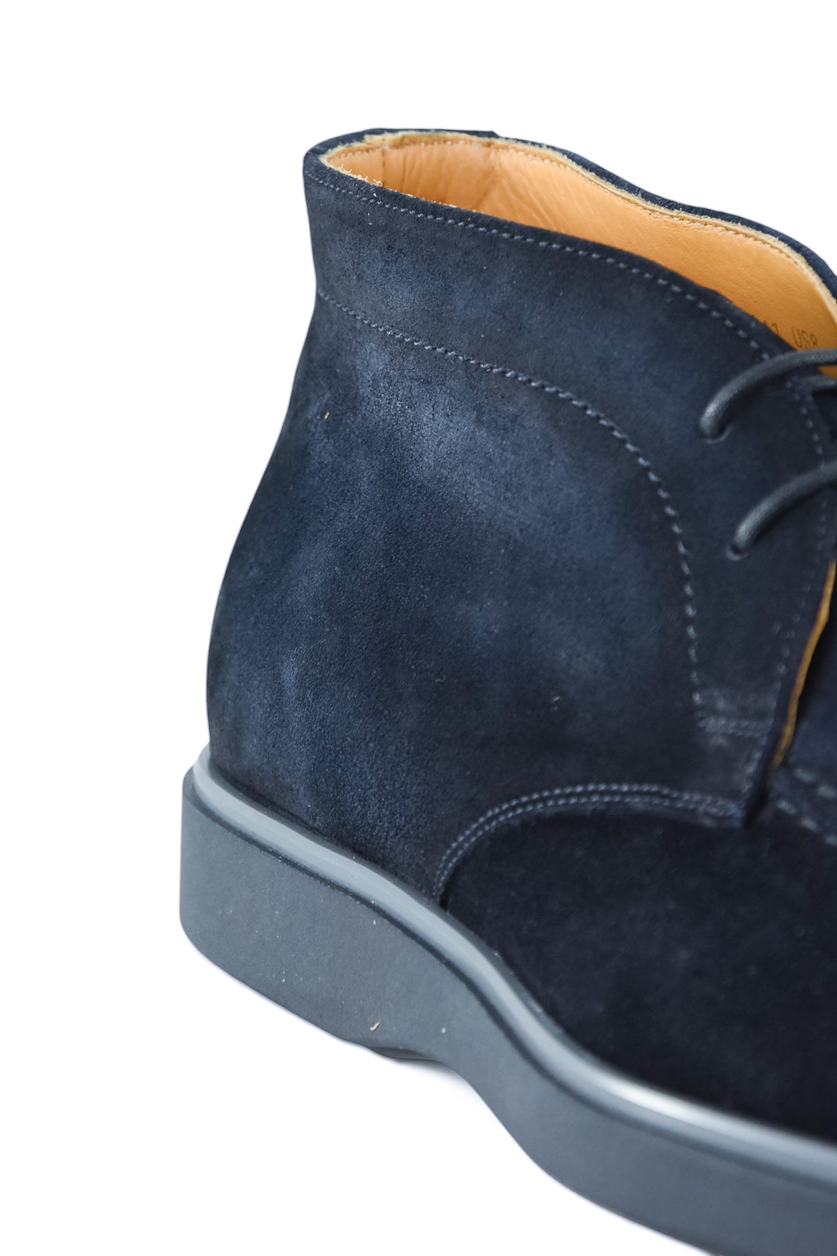 Toe and quarter view of blue suede chukka desert boot with lace-up and sole.