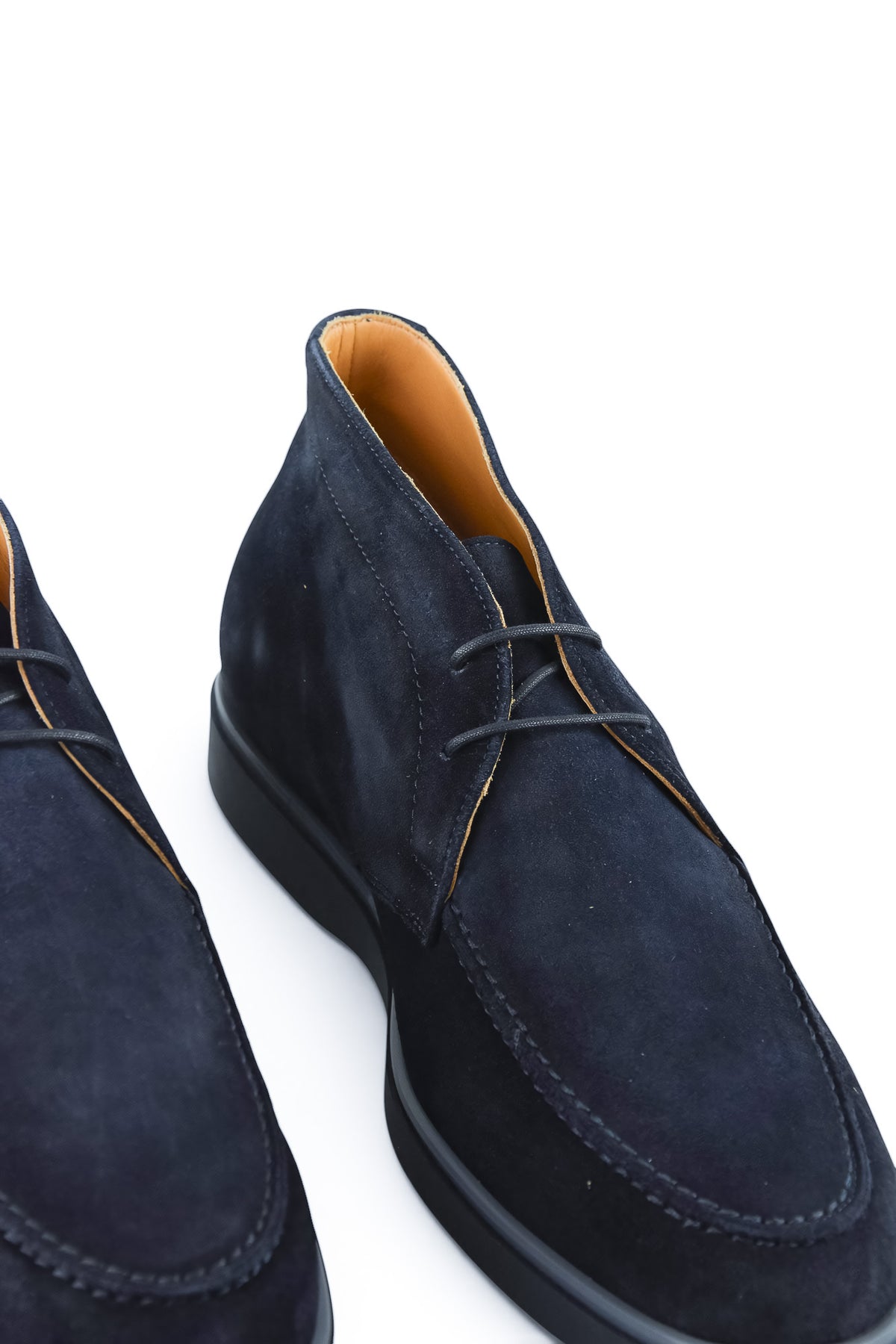 Two blue suede chukka desert boots shown at an angle with lace-up fronts.